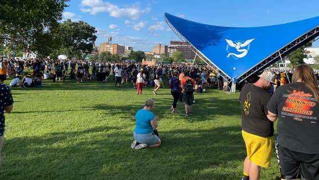 A crowd is shown standing next to a blue tent with an Articuno decal on the center.