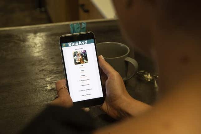 A woman looking at a phone screen with the BlueAvo website open.