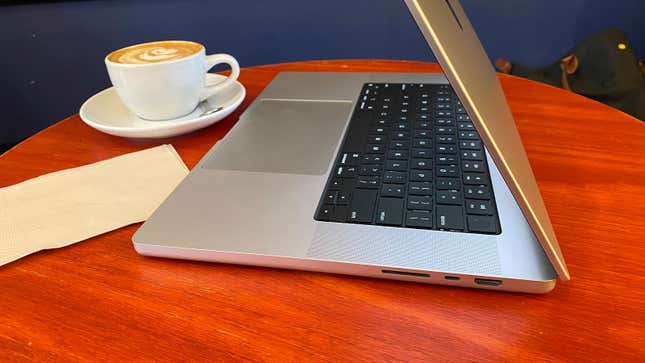 A 16 inch MacBook Pro next to a cup of coffee