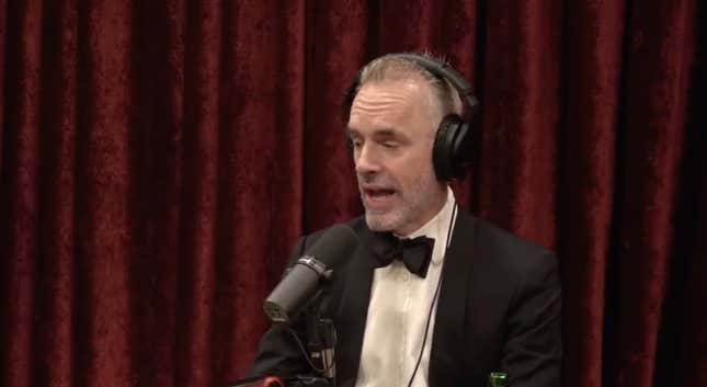 Jordan Peterson wearing a bow tie and talking into a microphone.