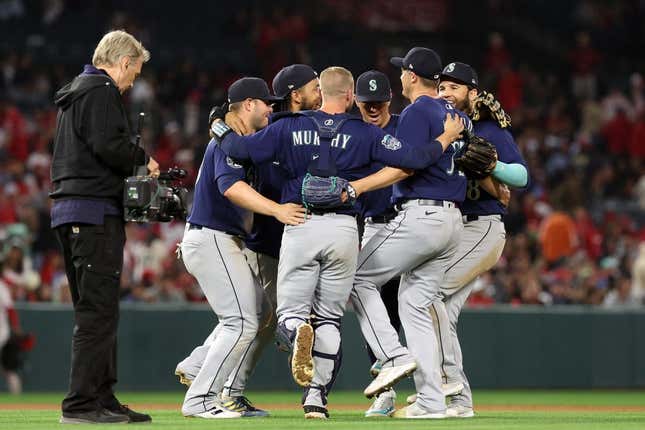 Jun 10, 2023; Anaheim, California, USA; Seattle Mariners infielders celebrate a victory against the Los Angeles Angels after defeating the Angels 6-2 at Angel Stadium.