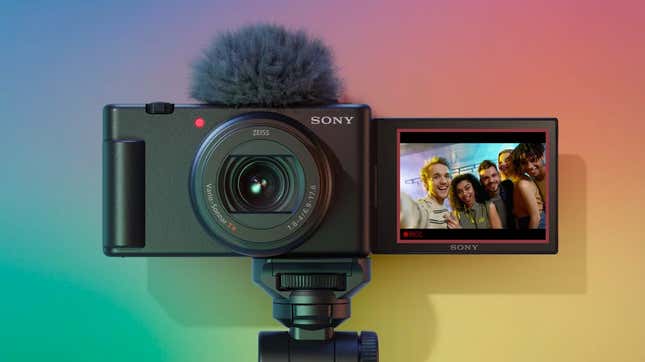 A shot of the front of the Sony ZV-1 II digital camera with its LCD display flipped around against a rainbow background.