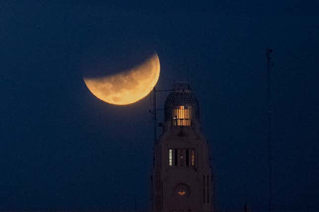 The moon sets behind the Montevideo port, in Uruguay, Wednesday, May 26, 2021
