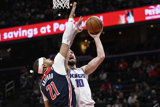 Mar 18, 2023; Washington, District of Columbia, USA; Sacramento Kings forward Domantas Sabonis (10) shoots over Washington Wizards center Daniel Gafford (21) during the first half at Capital One Arena.