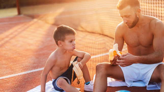 parent and son on tennis court eating bananas
