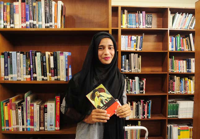 Formin Akter, a Rohingya refugee girl, holds a copy of the novel Jane Eyre, which she says is her new favourite book, inside the library of the Asian University for Women in Chittagong
