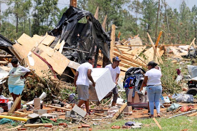 Friends and relatives help remove belongings from Adrian Cole’s damaged home after a tornado struck off Country Road 16, on June 19, 2023 in Louin, Mississippi.