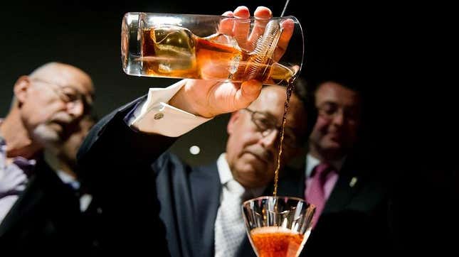 man pouring cocktail into glass