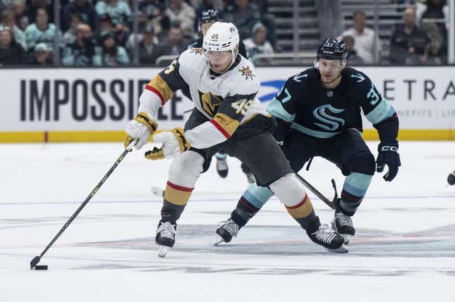 Apr 13, 2023; Seattle, Washington, USA; Las Vegas Knights forward Ivan Barbashev (49) skates with the puck against Seattle Kraken forward Yanni Gourde (37) during the first period at Climate Pledge Arena.
