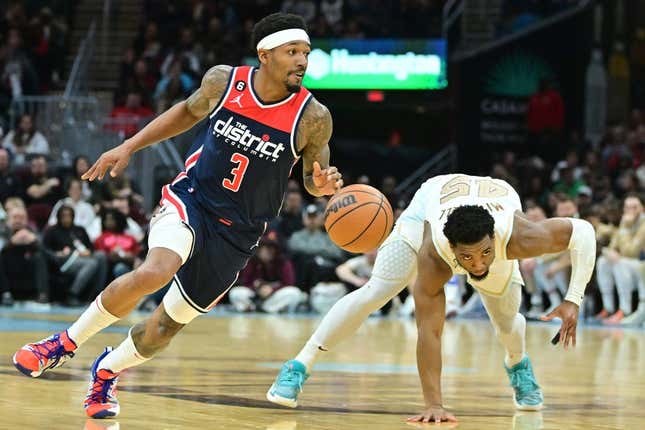 Mar 17, 2023; Cleveland, Ohio, USA; Washington Wizards guard Bradley Beal (3) and Cleveland Cavaliers guard Donovan Mitchell (45) go for a loose ball during the second half at Rocket Mortgage FieldHouse.