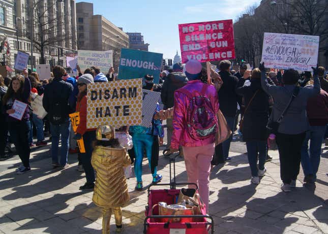 Marchers holding signs pass by the Trump International Hotel.