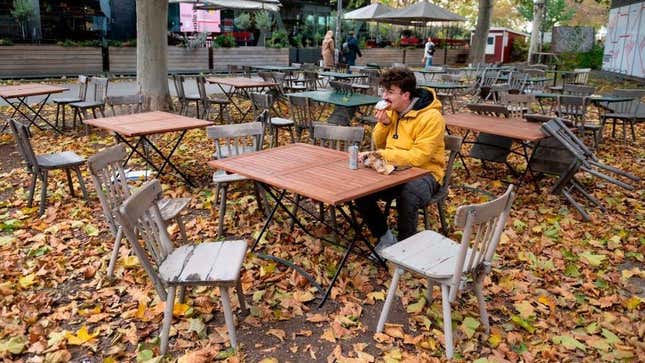 Man eats food in abandoned restaurant patio area