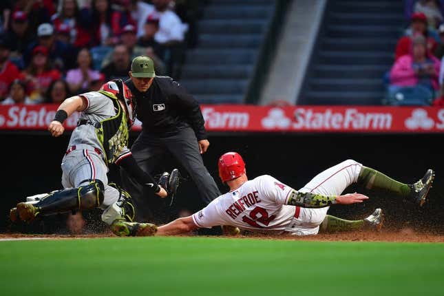 May 19, 2023; Anaheim, California, USA; Los Angeles Angels right fielder Hunter Renfroe (12) scores a run ahead of Minnesota Twins catcher Ryan Jeffers (27) during the fourth inning at Angel Stadium.