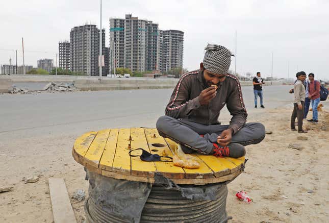 A migrant worker eats food offered by local residents on a highway in Ghaziabad.