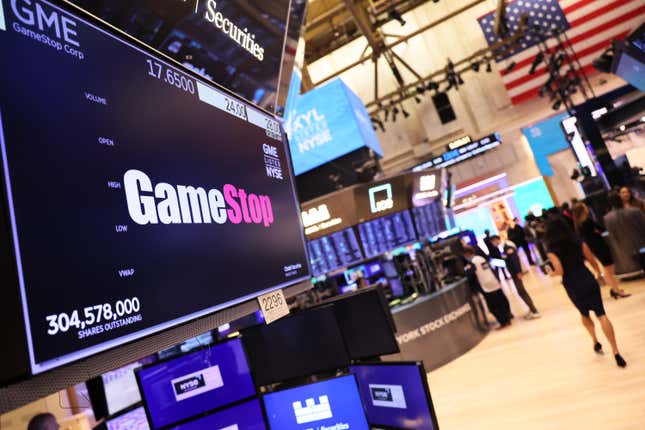 A stock trading floor showing the GameStop logo on a screen