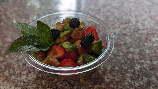 Fruit salad with mint in a bowl on the counter