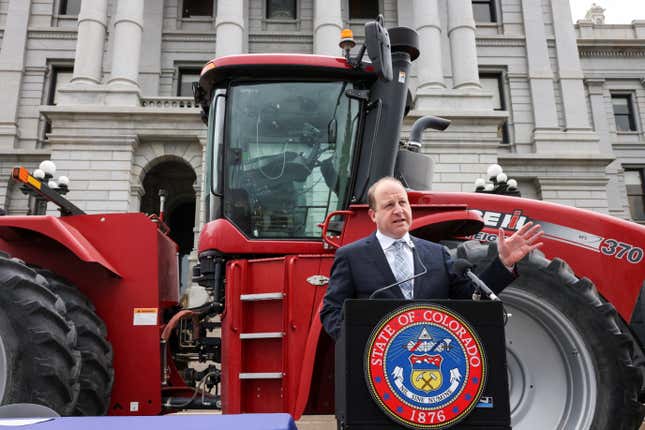 Governor Jared Polis posed with a tractor outside the Colorado State House.