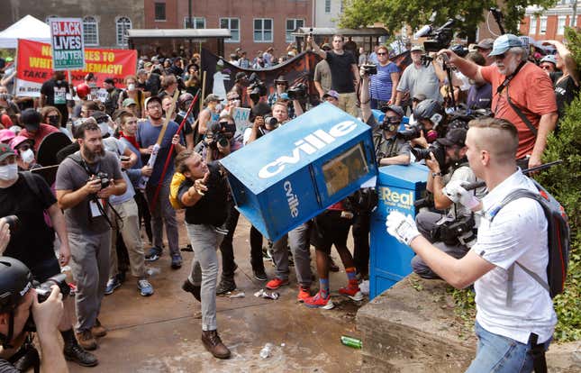 A counter-demonstrator throws a newspaper box at white nationalists at the entrance to Lee Park.