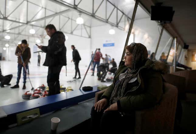 A refugee from Afghanistan looks out as she watches her family learn to curl. (Reuters/Mark Blinch)