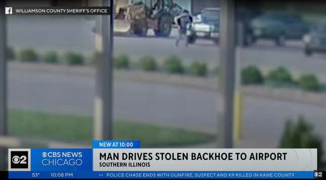 screenshot from cbs news chicago video with a man driving away a construction backhoe viewed from the inside of someone's home through the window
