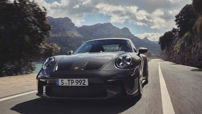 A photo of a grey Porsche 911 driving on a highway. 