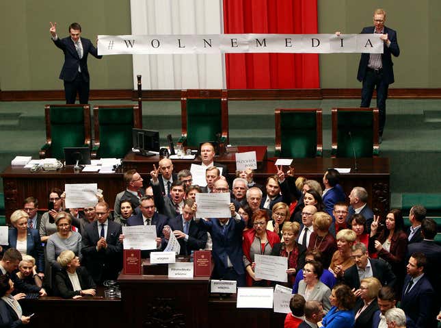 Opposition lawmakers sing the national anthem and chant as they occupy the podium to protest in the lower house of parliament in Warsaw, Poland, on Friday, 16 Dec. 2016. They protested in a large group around the podium against the ruling party pans to limit reporters' access to lawmakers. (AP Photo/Czarek Sokolowski)