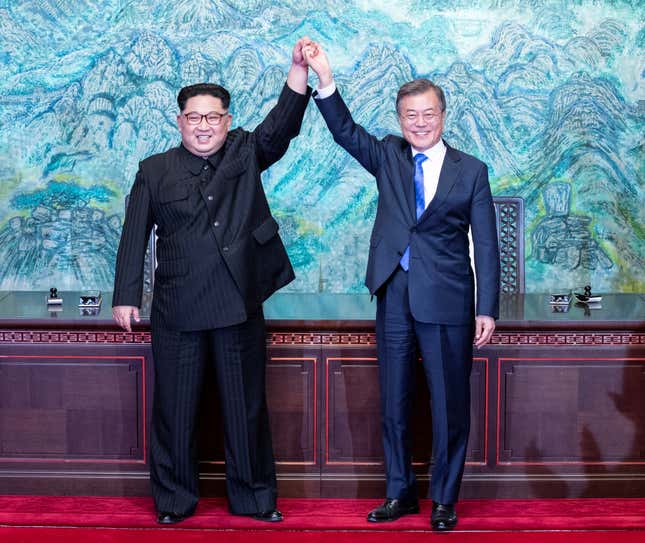 The leaders raise their hands at the truce village of Panmunjom inside the demilitarized zone.