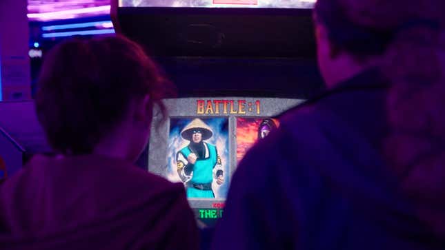 Ellie and Riley are shown getting ready to play a round of Mortal Kombat II on an arcade cabinet.