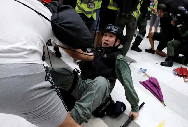 An activist scuffles with a police officer in a Hong Kong mall, July 14, 2019.