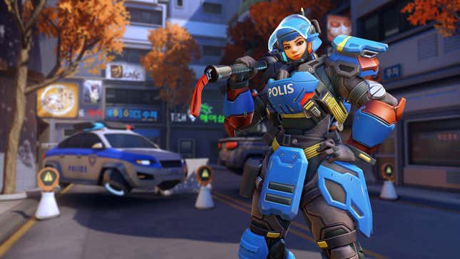 Brigitte poses in front of a police car on the Busan map in Overwatch.