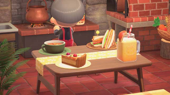 An Animal Crossing villager cooks in a kitchen while a sandwich, soup, pie, and drink sit displayed on a table. 