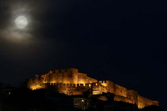 Full moon rises next to the ancient castle of Mithymna Molyvos on the Greek island of Lesbos.