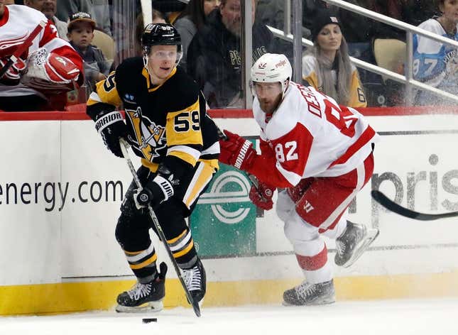Dec 28, 2022; Pittsburgh, Pennsylvania, USA;  Pittsburgh Penguins left wing Jake Guentzel (59) moves the puck against Detroit Red Wings defenseman Jordan Oesterle (82) during the first period at PPG Paints Arena.