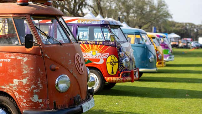 A photo of a row of brightly-colored VW buses. 