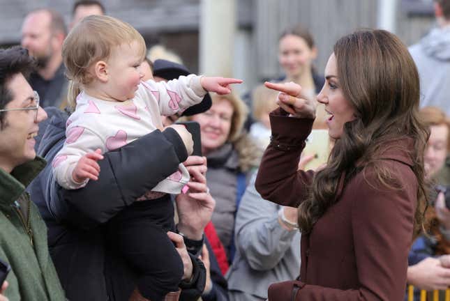 The Duchess of Cambridge and a toddler greet each other. 