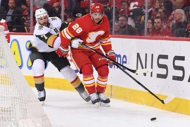 Oct 18, 2022; Calgary, Alberta, CAN; Calgary Flames forward Elias Lindholm (28) and Las Vegas Golden Knights defenseman Alex Pietrangelo (7) chase after the puck in the third period at Scotiabank Saddledome. Flames won 3-2.