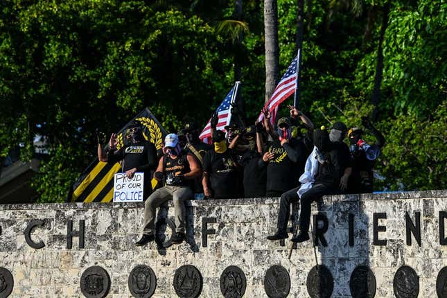 Members of the Proud Boys gesture at the Torch of Friendship, protesting towards people gathered to remember George Floyd on their star anniversary of his death at the hands of a police officer, in Miami on May 25, 2021. - The family of African American George Floyd appealed today for sweeping police reform on the anniversary of his murder by a white officer as they met President Joe Biden at the White House. The legislation being considered to increase police accountability would be named after Floyd, who suffocated after being pinned down under the knee of Minneapolis officer Derek Chauvin on May 25, 2020