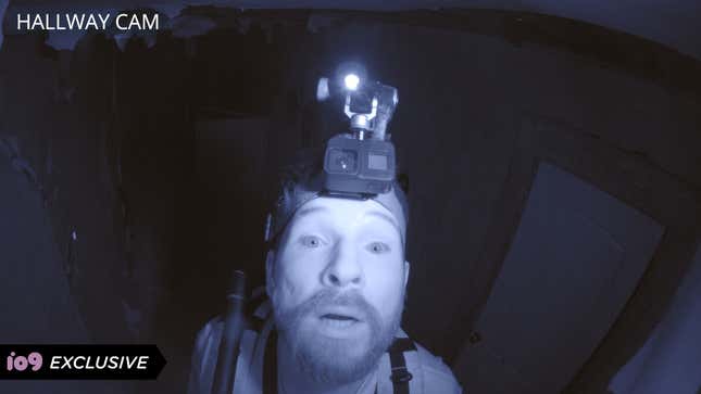 A man with a camera on his head, illuminated in night vision.