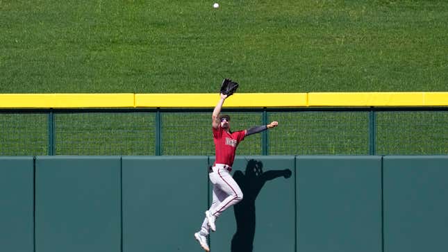 Corbin Carroll leaps at the wall to make a catch on a fly ball hit by Chicago Cubs’ Cody Bellinger