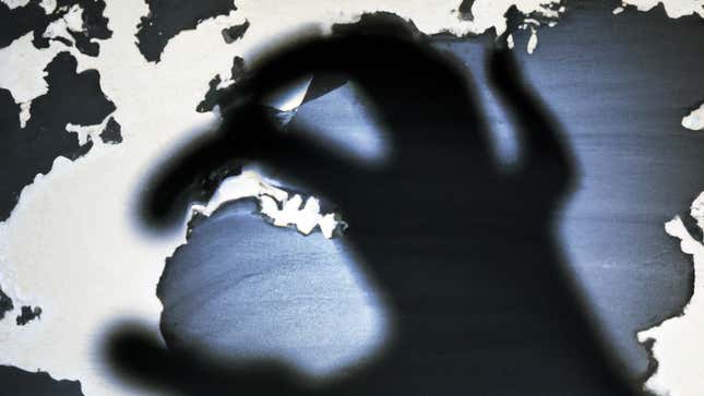 The shadow of a hand looms over some sort of map.
