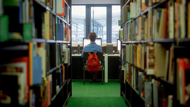 Student studying along in a library