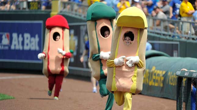 Three people in hot dog costumes racing long baseline at ballpark for Hot Dog Derby
