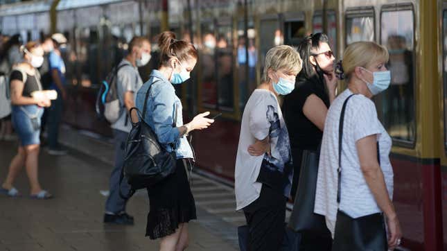 Commuters wearing protective face masks board a train on August 07, 2020 in Berlin, Germany.