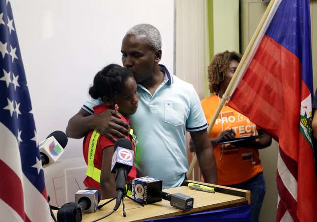 Rony Ponthieux, right, hugs his daughter, 10, during a news conference in favor of extending TPS. Rony has been in the US for 18 years on TPS status.