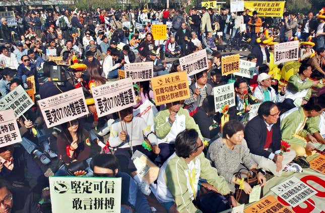 Demonstrators hold placards as more than 1,000 people rallied and later marched in downtown Hong Kong on Sunday, Jan. 23, 2005, to demand full democracy and social justice in the Chinese territory. The protesters chanted: "Direct elections in 2007 and 2008", the years in which Hong Kong is due a to get new leader and legislature. This former British colony was handed over to Chinese rule in 1997 with a guarantee of democratic political rights that do not exist on the mainland, but many residents who want democracy say Beijing exerts too much control here. The Chinese characters on the placards read: "Direct elections in 2007-8", "Against the collusion between the government and businesses".
