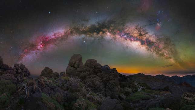 The pinkish Milky Way arch, with rocks below.