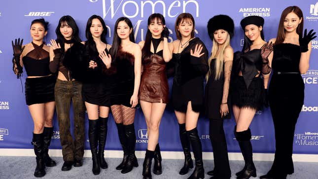 K-pop group TWICE. Chaeyoung is third from the right, wearing a black hat and with her arms at her side