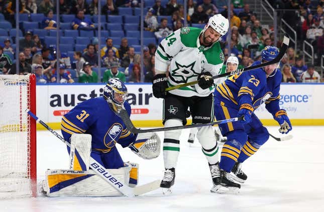 Mar 9, 2023; Buffalo, New York, USA;  Buffalo Sabres goaltender Eric Comrie (31) watches as Dallas Stars left wing Jamie Benn (14) gets hit wit the puck during the first period at KeyBank Center.