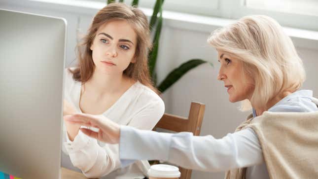 Older woman and younger woman talking and looking at computer screen