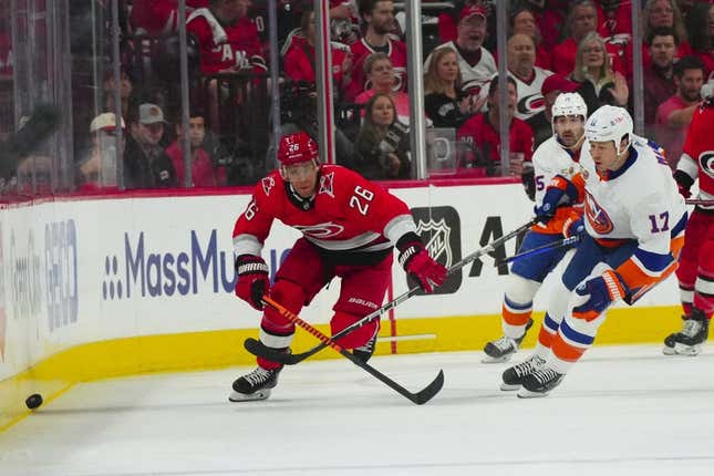 Apr 19, 2023; Raleigh, North Carolina, USA; Carolina Hurricanes center Paul Stastny (26) and New York Islanders left wing Matt Martin (17) chase after the puck during the first period in game two of the first round of the 2023 Stanley Cup Playoffs at PNC Arena.